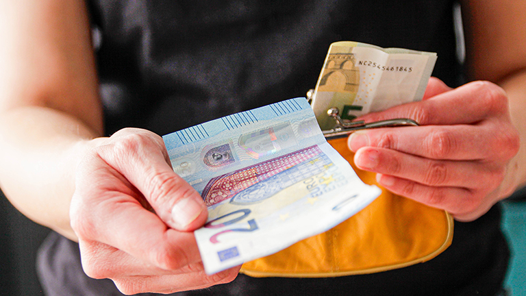 Handen met briefgeld uit portemonnee
