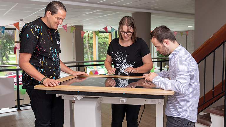 Drie mensen bij belevenistafel