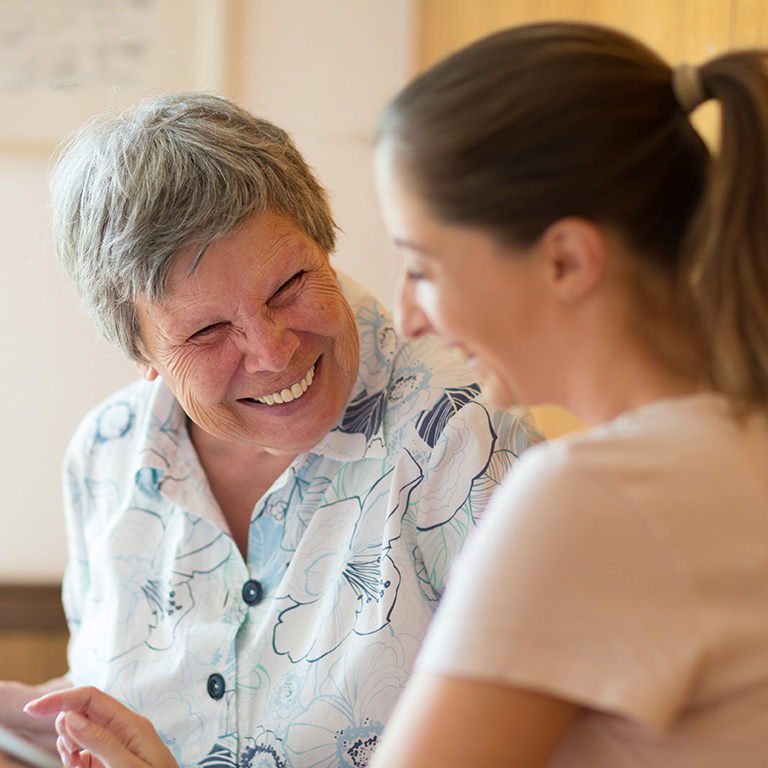 Twee vrouwen lachend in gesprek
